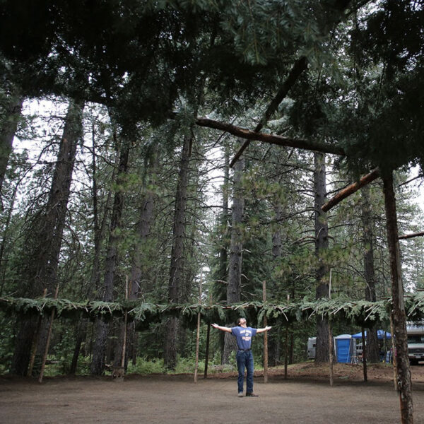 McCloud, CA — A Winnemem Wintu friend celebrates after completing preparation of a dance arbor near the base of Mt. Shasta. — Aug. 11, 2019