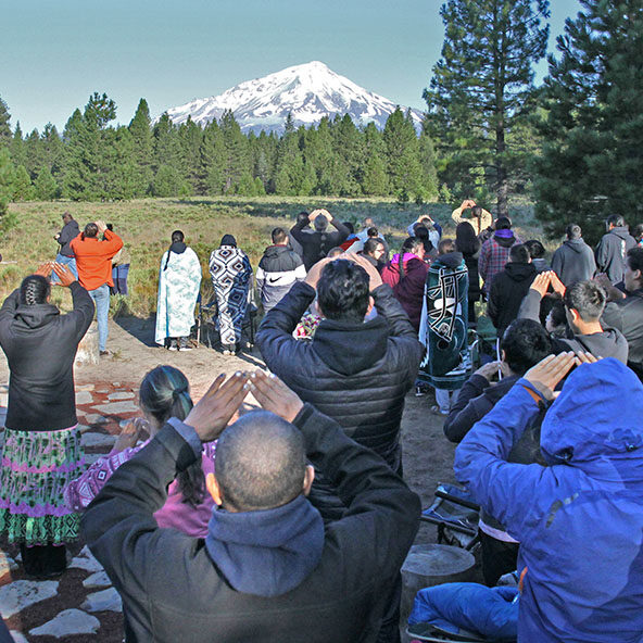 McCloud, CA — The Winnemem Wintu and friends gather for a sunrise ceremony near the base of Mt. Shasta. That morning, on the mountain’s slopes, they saw an image of a bear with a salmon. — Aug. 11, 2019
